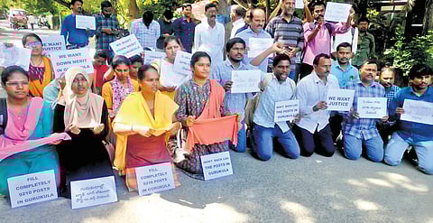 Teaching job aspirants stage a protest kneeling down outside the residence of Chief Minister A Revanth Reddy on Wednesday