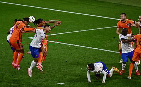 Netherlands' defender #04 Virgil van Dijk (L) jumps to head the ball during the UEFA Euro 2024 Group D football match between the Netherlands and France at the Leipzig Stadium in Leipzig on June 21, 2024.