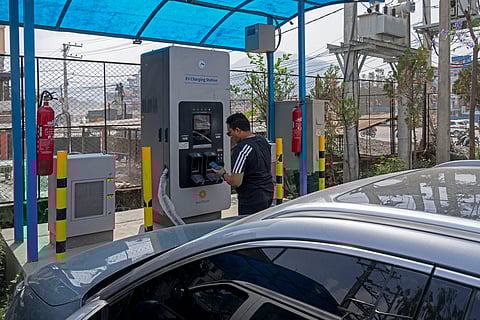 A man charges his electric vehicle at a charging station in Kathmandu.