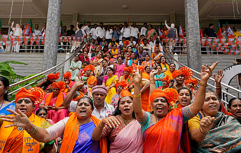 Supporters, clad in saffron scarves, engaged in animated discussion as they watched the rise and fall in numbers