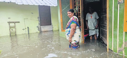 A woman at her house that got inundated with sea water in Kannamaly