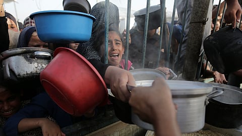 A Palestinian girl reacts as she collects food aid ahead of the upcoming Eid al-Adha holiday in Jerusalem.