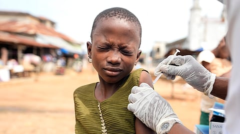 A health worker administers a cervical cancer vaccine HPV Gardasil to a girl on the street in Ibadan, Nigeria.