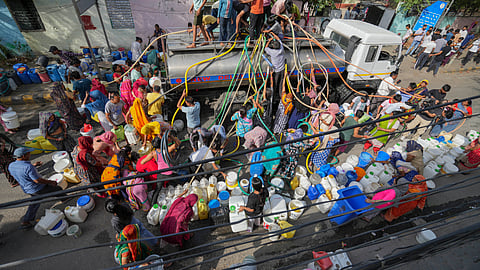 People collect drinking water from a tanker amid ongoing Delhi water crisis, at Vivekanand camp in New Delhi, Thursday.