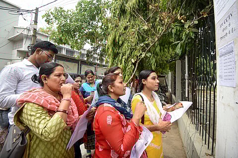 Aspirants search their roll numbers for seats before entering an examination center to appear in the UGC-NET exam, at AN college in Patna, Tuesday, June 18, 2024.