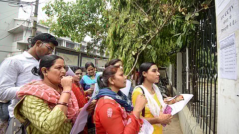Aspirants search their roll numbers for seats before entering an examination center to appear in the UGC-NET exam on June 18 in Patna.