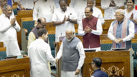Prime Minister Narendra Modi and LOP Rahul Gandhi exchange a handshake as they accompany newly elected Lok Sabha speaker Om Birla to the chair, at Parliament House in New Delhi on Wednesday, June 28, 2024.