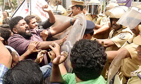 Police use force to stop workers of SFI, who were leading a protest march demanding an inquiry into the alleged irregularities in NEET exam.