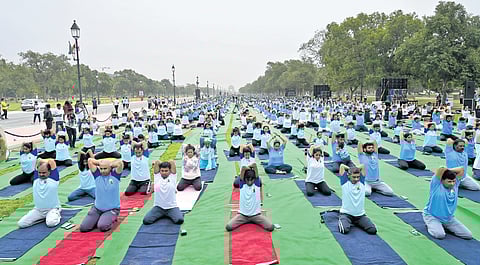 People perform yoga to mark the International Yoga Day at Kartavya Path lawn in New Delhi on Friday