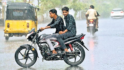 Commuters ride during rain in Karimnagar on Sunday