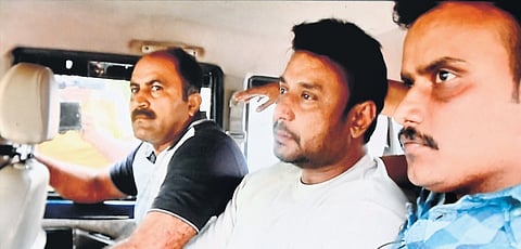 Police take actor Darshan (centre) into custody, for his alleged involvement in the murder of S Renukaswamy