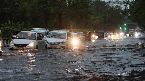 Vehicles crawl through a waterlogged road amid rains, in New Delhi, Friday morning.