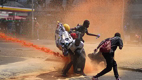 Protesters scatter as Kenya police spray water canon at them during a protest over proposed tax hikes in a finance bill in downtown Nairobi.