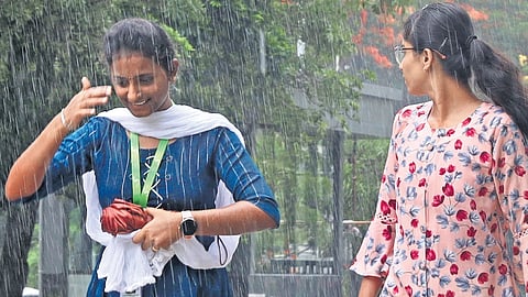 People enjoy the rain at Madhapur in Hyderabad on Friday.