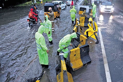A GHMC Directorate Of Enforcement Vigilance and Disaster Management team clears the waterlogged Raj Bhavan road in Hyderabad on Sunday