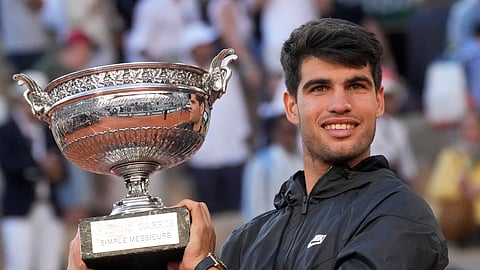 Spain's Carlos Alcaraz holds the trophy after winning the men's final of the French Open tennis tournament against Germany's Alexander Zverev at the Roland Garros stadium in Paris.