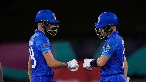 Afghanistan batsmen Ibrahim Zadran, left, and Rahmanullah Gurbaz bump gloves while batting against Uganda during an ICC Men's T20 World Cup cricket match on June 3, 2024.