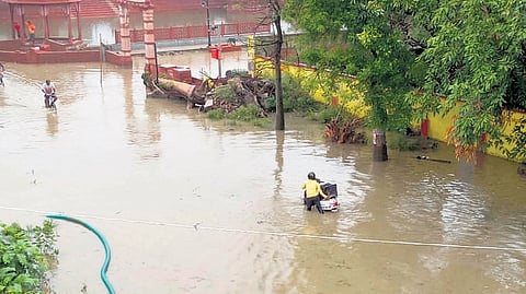 A Man wades through flooded road in the Jalwanpura of Ayodhya on Saturday.