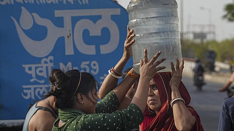 File image used for representational purposes | A woman carries drinking water collected from a tanker of Delhi Jal Board on a hot summer