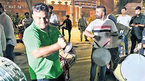 AAP workers dance in front on party’s office in New Delhi on Thursday