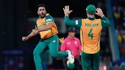 South Africa's Tabraiz Shamsi celebrates with teammate Aiden Markram after taking the wicket West Indies' Sherfane Rutherford during the ICC Men's T20 World Cup cricket match between the West Indies and South Africa on June 23, 2024.
