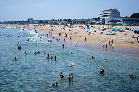 The cool waters of the Atlantic Ocean attract a crowd to Old Orchard Beach, Maine.