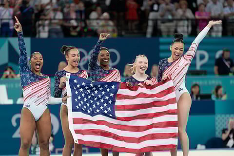 Members of Team USA celebrate after winning the gold medal in the women's artistic gymnastics team finals round of the 2024 Paris Olympics