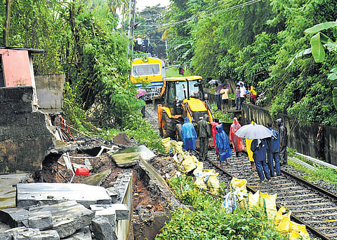 Workers clear debris from the railway line to Pollachi near the Robinson Road gate in Palakkad town on Tuesday morning