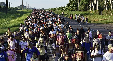 Migrants walk along the highway through Suchiate, Chiapas state in southern Mexico, Sunday, July 21, 2024, during their journey north towards the U.S. border.