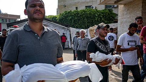 Palestinians hold the bodies of their relatives killed in the Israeli bombardment of the Gaza Strip, at a hospital in Deir al-Balah, Sunday, July 21, 2024.