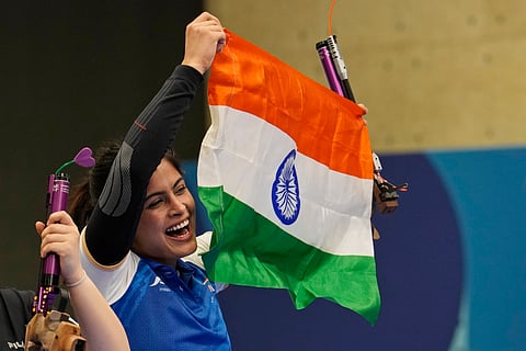 Manu Bhaker celebrates with the Indian flag after winning the bronze medal in the 10m air pistol women's final round at the 2024 Summer Olympics, Sunday, July 28, 2024, in Chateauroux, France.