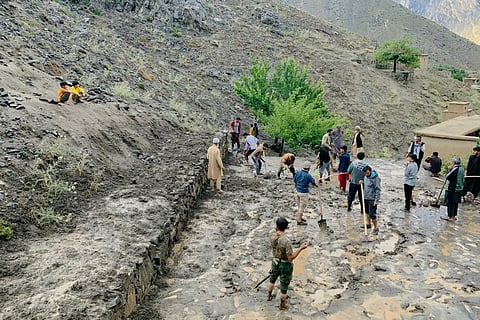 Afghan residents shovel mud following flash floods after heavy rainfall at Pesgaran village in Dara district, Panjshir province on July 15, 2024.