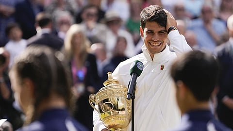 Carlos Alcaraz reacts as he is interviewed on court after his victory over Novak Djokovic in the men's singles final at the Wimbledon tennis championships in London, Sunday, July 14, 2024.