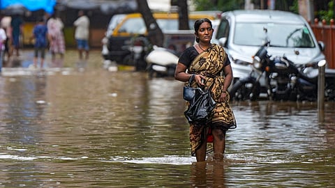 A woman walks through a waterlogged road after rains, in Mumbai.