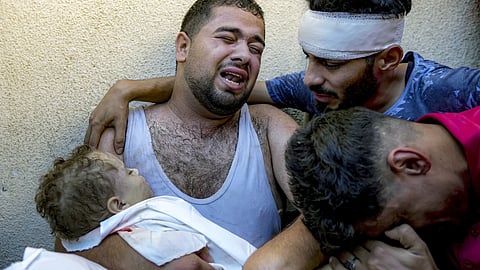 Palestinian Mahmoud Mikdad mourns holding the body of his 21-month-old child Yamam, killed in the Israeli bombardment of the Gaza Strip, at a hospital morgue in Deir al-Balah, Tuesday, July 16, 2024.