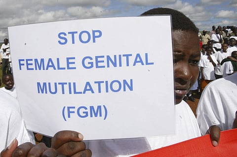 A Masai girl holds a protest sign during the anti-Female Genital Mutilation (FGM) run in Kilgoris, Kenya, on April 21, 2007.