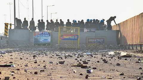 Security forces stand guard as brick bats and stones lie on the road at the Punjab-haryana Shambu border during farmers' 'Delhi Chalo' protest march near Patiala district.