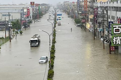 People and vehicles wade through the water along a street that was flooded by Typhoon Gaemi in Kaohsiung: Representational image.