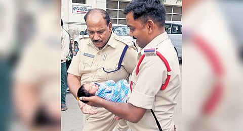 Police seen holding the rescued newborn at Anantapur Government General Hospital