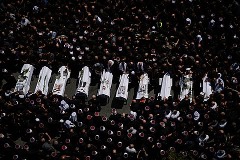 Mourners from the Druze minority surround the bodies of some of the 12 children and teens killed in a rocket strike at a soccer field.
