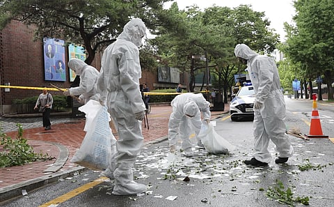 Officers wearing protective gear collect the trash from a balloon presumably sent by North Korea, Wednesday, July 24, 2024, in Seoul, South Korea.