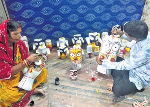 Lina Moharana and her son giving final touches to miniature idols of the Trinity