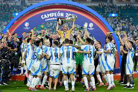 Argentina kitman Mario De Stefano holds up the trophy as he celebrates with players after defeating Colombia in the Copa America finals.