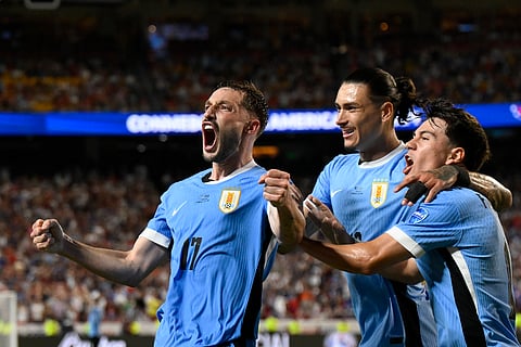 Uruguay's Matias Vina, left, celebrates his side's opening goal against United States scored by teammate Mathias Olivera during a Copa America match