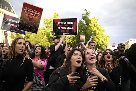 French voters react to the projected results of the second round of legislative elections, near Republique Plaza in Paris, July 7, 2024.