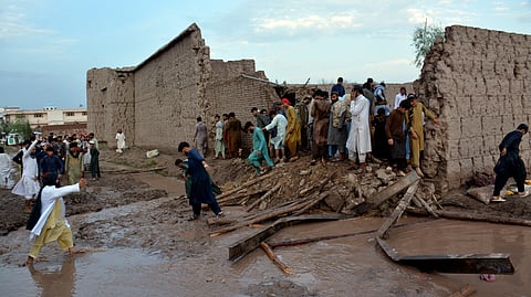 People gather to clear the rubble of a house partially damaged by landslide due to heavy rainfall in Surkhroad district of Jalalabad, Nangarhar province east of Kabul, Afghanistan.