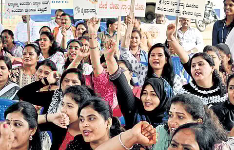 Members of Bengaluru Beautician Women’s Trust raise slogans during their protest at Freedom Park in Bengaluru on Friday
