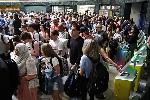 People wait for their flight after a global outage at LaGuardia Airport in the Queens borough of New York, on July 19, 2024.