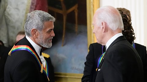 US President Joe Biden (R) shakes hands with actor, director and producer George Clooney during the Kennedy Center honorees reception at the White House in Washington, Dec. 4, 2022.
