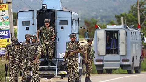 Security personnel conduct a search operation following reports of suspicious movement of two suspected terrorists.